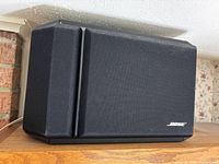 Side angled view of one Bose 301 speaker showing fabric cover and Bose logo