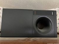 Front view of the Bose black Acoustimass subwoofer showing the bass port and Bose branding.
