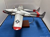 Front-side angle of the white 1/72 scale model of the Fairchild C-119 airplane with U.S. Air Force markings on a wooden base.