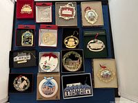 Group photo of all 15 commemorative ornaments arranged in rows, each in original packaging