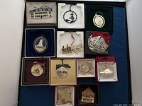 Set of 12 metal commemorative ornaments in display boxes showing diverse historic site designs