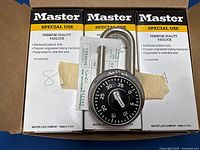 Six Master brand combination padlocks in original boxes with one padlock visible showing black dial and silver metal shackle