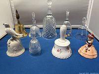 Front view displaying all nine decorative bells on blue cloth background