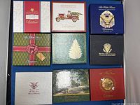 Boxed set of nine White House Historical Association Christmas Ornaments arranged on blue surface.