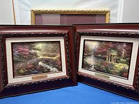 Two framed prints side by side: Bridge of Faith (left) and Garden of Prayer (right) in wooden frames with carved accents.