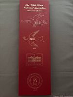 Red box with gold embossed ornamental designs and year markings 1981, 1982, 1984, 1986