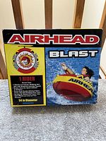 Front side of the Airhead Blast box with graphic of rider on tube and bullet points highlighting features.