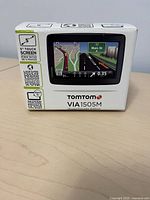 Box of TomTom VIA 1505M GPS navigator showing brand, model, and some specifications including 5 inch touchscreen.