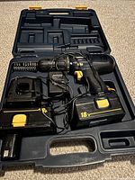 Open black hard plastic case showing Mastercraft cordless drill, two 18V batteries, and charger inside.