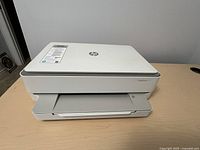 Front view of HP ENVY 6055 printer with output tray extended, showing overall condition and design.
