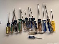 14 assorted screwdrivers of various sizes and handle colors, mostly Craftsman brand