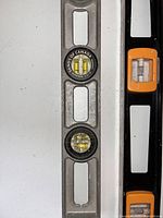 Close-up photo of part of one metal level showing circular spirit vials and 'Sands of Canada' branding.