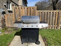 Front view of grill with closed lid and side shelves