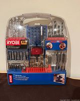 Clear view of the closed accessory kit showing all bits and sockets included with RYOBI brand and 90-piece set label.