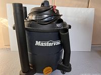Full front view of the Mastervac wet/dry vacuum showing the body and two rigid extension tubes attached to the sides.