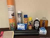 Overview of various household cleaning products including HDX Super Absorbent Shammy, Easy Liner shelf liner, disinfectant wipes, Goof Off Max Gel spray, Method dish soap, Downy Ball dispenser, blue and white cleaner spray, Scotch-Brite sponge.