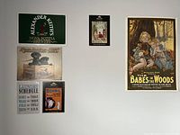 All six signs and posters mounted on wall: metal signs for Alexander Keith's Brewery, Remington-UMC, Laundry Schedule, Bovril; poster of The Babes in the Woods; small vintage beverage ad poster