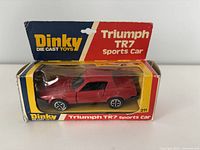 Front view of the diecast red Triumph TR7 sports car inside original Dinky box showing the branding and packaging condition.