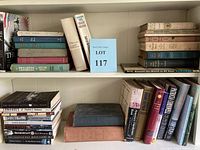 Full view of two shelves with assorted hardcover and paperback books in history, fiction, reference categories, presence of blue and beige spines.