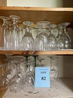 Top shelf showing clear vintage wine glasses of various shapes and sizes arranged side by side.
