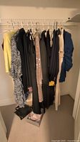 Overview of hanging garments including blazers, dresses, skirts and tops