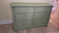 Front view of green painted 6 drawer dresser showing all drawers and acrylic pulls.