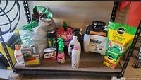 Shelf with mixed garden chemical products including CLR, Miracle Gro, Spectracide, Roundup, soil bags, and pesticide sprays.