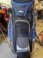 Front view of Golf Trends golf bag showing logo, multiple zippered compartments and storage pockets