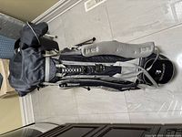 Full view of the grey and black Sun Mountain golf bag standing upright showing padded shoulder straps and stand legs.