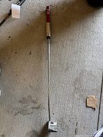 Full length view of left-handed Cameron putter on concrete floor