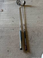 Both putters side by side showing shafts and grips