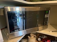 Front view of stainless steel Panasonic inverter microwave positioned on kitchen counter.