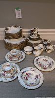 Overview of stacked dinner plates, luncheon plates, soup bowls, cups, saucers, creamer and sugar bowl