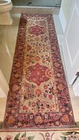 Long shot of entire hooked runner rug showing pattern and size in narrow bathroom setting