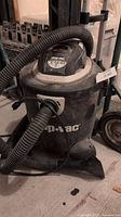 Front side of the Shop-Vac wet dry vacuum showing attached hose and body.