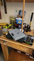 Photo showing various tools on wooden workbench including Minwax PolySpar can, tool cases, and hardware pieces