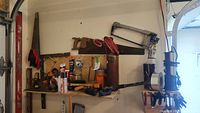 Wall-mounted hand saws, hack saw, clamps on shelf and assorted tools