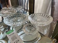 Three Waterford crystal ashtrays displayed in glass cabinet showing various sizes and cut-glass patterns.