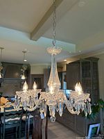 Full view of chandelier hanging by chain in kitchen setting