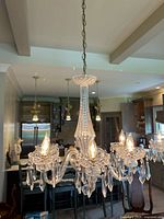 Full view of chandelier hanging over island in kitchen, showing all six arms and dangling prisms