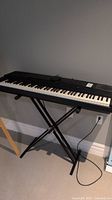 Full view of the Yamaha YPP-55 folding keyboard on stand, showing keys and overall layout.