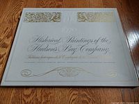 Top view of the closed presentation box for the set, titled 'Historical Paintings of the Hudson's Bay Company 1670'. The box is light gray with gold embossed decorative text and design.