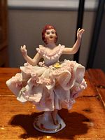 Front angle view showing detailed lace folds and facial features of porcelain figurine.