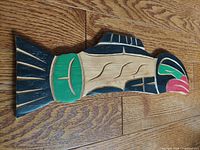 Top view of the hand carved wooden salmon wall art showing red, green, black, and natural wood paint