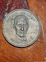 Close-up photo of a Shell Oil token featuring Arthur Meighen with inscription ARTHUR MEIGHEN and dates 1920-26 on a wooden table.