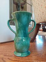 Front view of green Medalta pottery vase with two handles, showing overall shape and glaze condition.