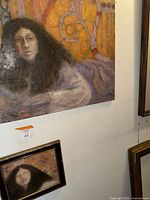 Photo showing the larger and smaller painting of the same woman, highlighting the detailed facial features and colorful background.