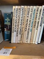 Books on shelf showing titles including Cleopatra memoirs, medieval hinting, classic literature and erotica collections