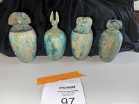 All four canopic jars front view against black backdrop