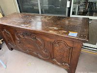 Full front view of carved oak desk, showing plank top and carved front panel